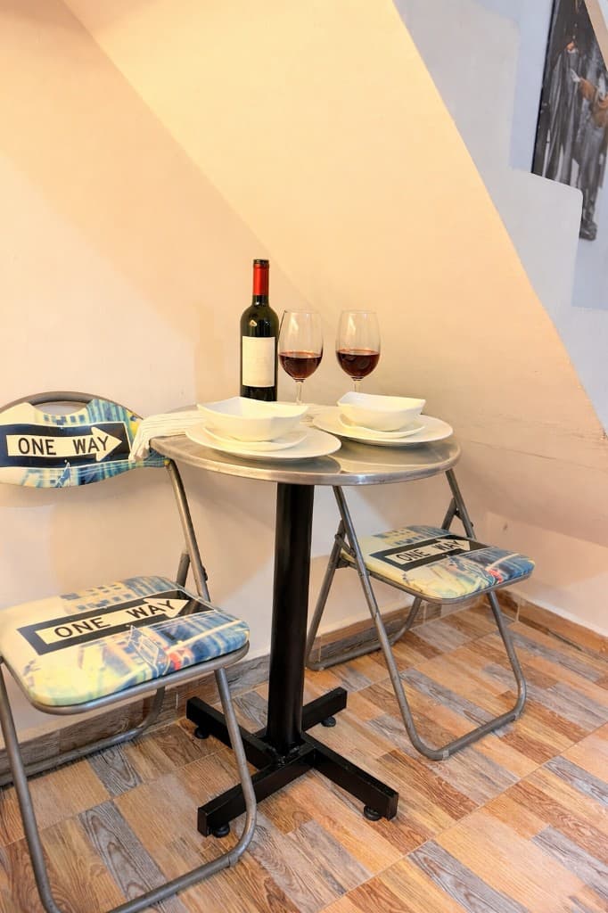 Mesa redonda con copas de vino y vajilla en rincón acogedor